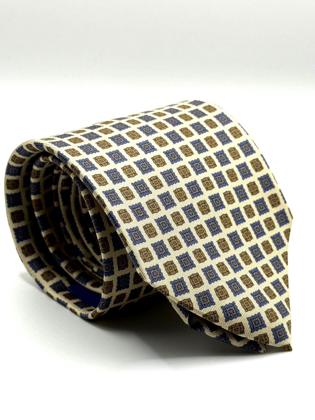 Corbata de seda Pergolesi crema con motivos geométricos azules y ocre